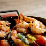 Cooked shrimp with tomatoes and herbs in a pan